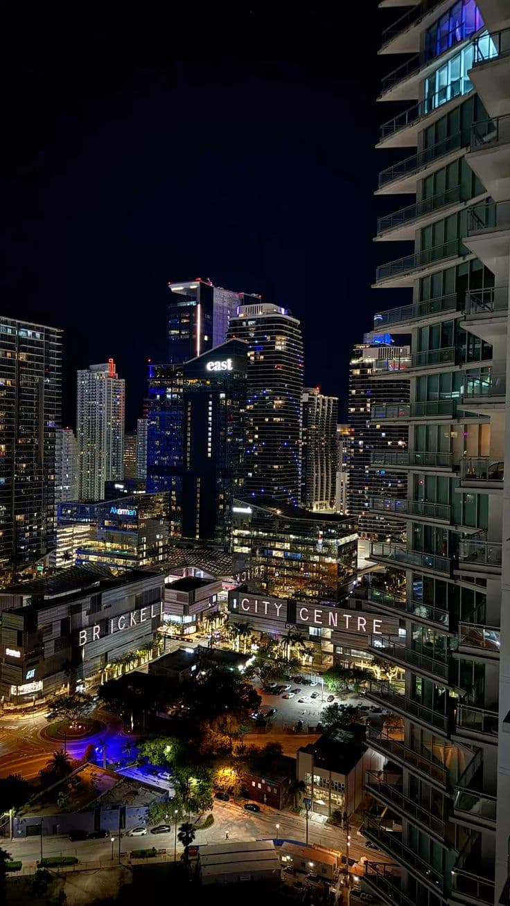 cityscape at night with skyscrapers and buildings in the foreground, lit up by bright blue