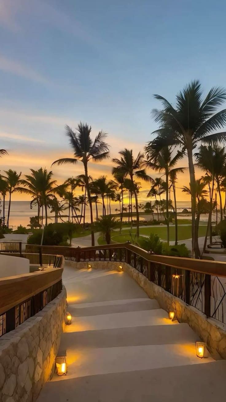 steps leading to the beach at sunset with palm trees in the background and lit candles on 