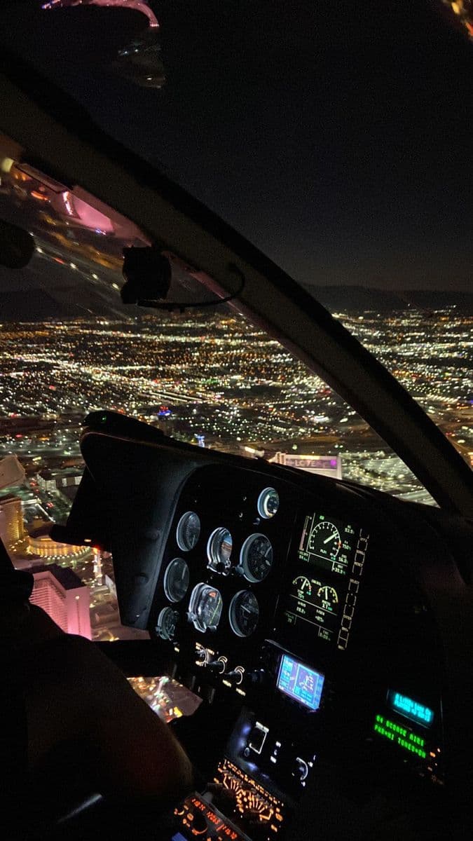 the view from inside an airplane at night, looking down on city lights and skyscrapers