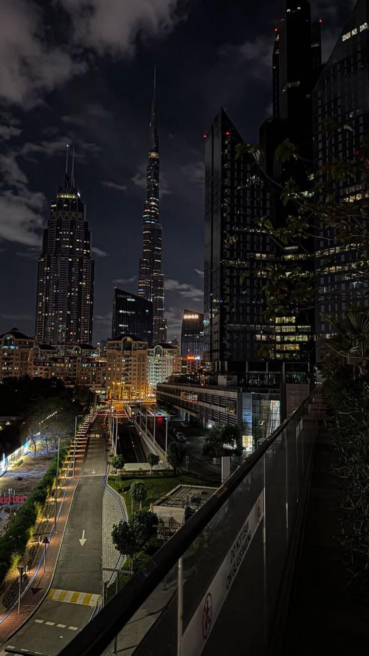 the city skyline is lit up at night, with skyscrapers in the back ground