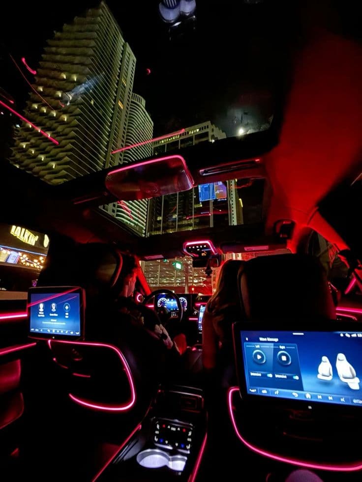 the interior of a car with neon lights and electronic gadgets on display at night