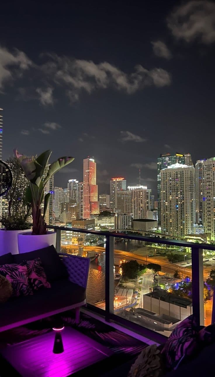 a balcony with purple lighting and cityscape in the background
