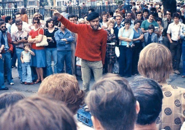 An orator standing above a crowd at Speakers' Corner in London, 1974, performing a speech to onlookers.