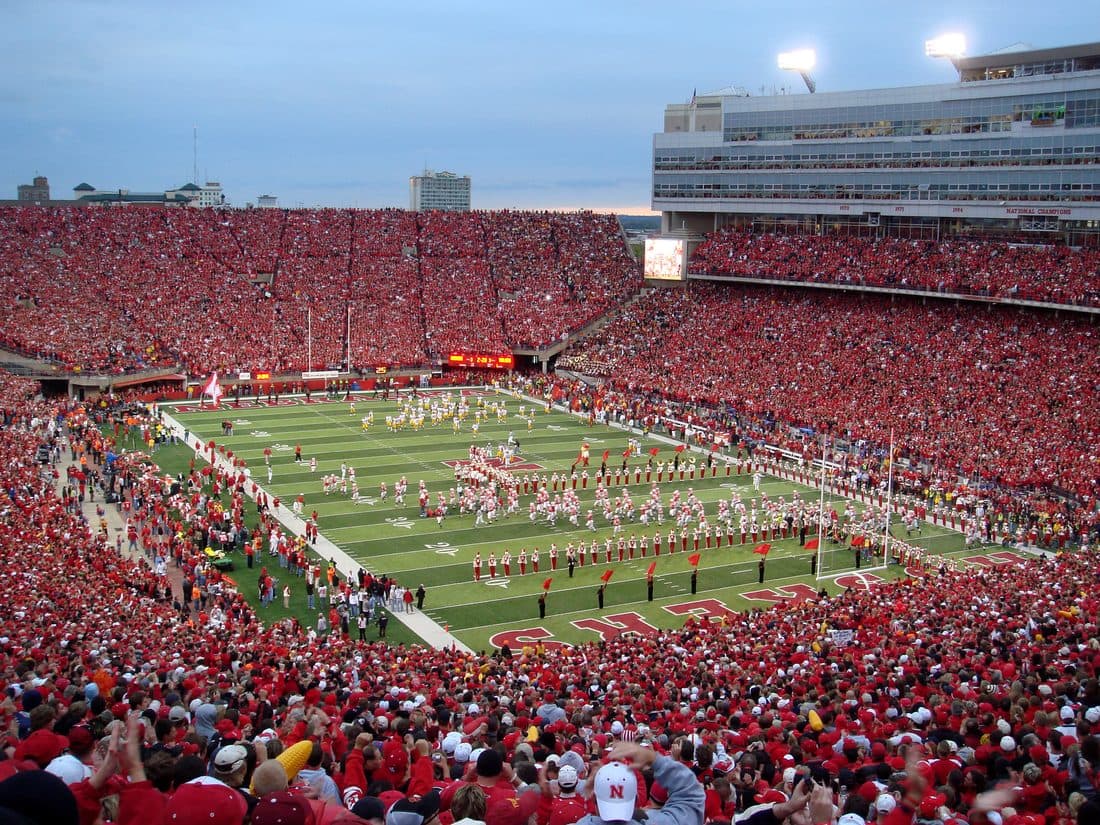 A packed stadium crowd of fans all wearing the same team colors, in-group belonging made visible